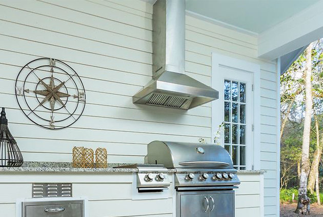 Outdoor kitchen with a vented hood over bbq